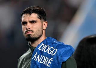 Pedro Neto #7 of Chelsea FC holds a jersey with the names Diogo and Andre